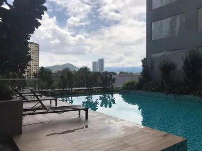 a swimming pool with two benches next to a building at Neu Suite by JS Home in Kuala Lumpur