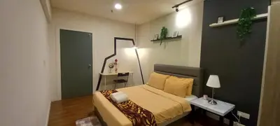 a bedroom with a bed and a table with a lamp at COZY TWO BEDROOM APARTMENT AT MERCU SUMMER in Kuala Lumpur
