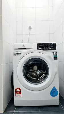 a white washing machine in a white room at Chambers Service Suites KLCC By Cozy Stay in Kuala Lumpur