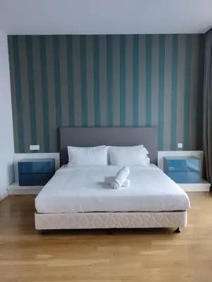 a bedroom with a white bed with green striped walls at Platinum KLCC & Bukit Bintang in Kuala Lumpur