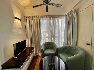 a living room with two chairs and a television at Couple Suite at Casa Mutiara 5 mins walk to LRT, Jalan Alor and Bukit Bintang in Kuala Lumpur
