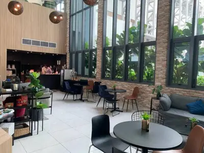 a lobby with tables and chairs in a building at Maxhome at The Luxe By Infinitum in Kuala Lumpur