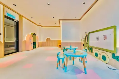a classroom with a table and two stools in a room at Scarletz Suites KLCC by M Suites in Kuala Lumpur