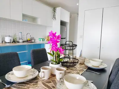 a dining room table with white dishes and pink flowers at City-View Studio Retreat with Spectacular View TRX in Kuala Lumpur