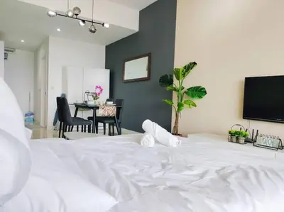 a large white bed in a room with a table at City-View Studio Retreat with Spectacular View TRX in Kuala Lumpur