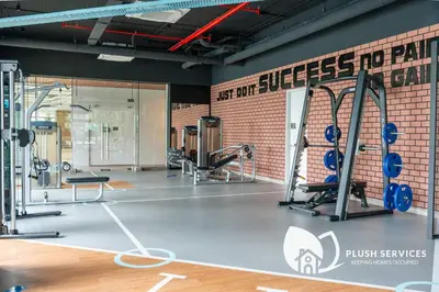 a gym with cardio equipment and a brick wall at Sentral Suites by Plush in Kuala Lumpur