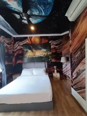 a bedroom with a bed with a painting on the wall at Titiwangsa9 Bungalow Pool Villa in Kuala Lumpur