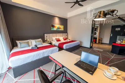 a bedroom with two beds and a desk with a laptop at Maison 101 Dang Wangi Kuala Lumpur KLCC in Kuala Lumpur