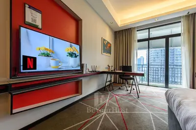a hotel room with a large tv and a desk at Maison 101 Dang Wangi Kuala Lumpur KLCC in Kuala Lumpur