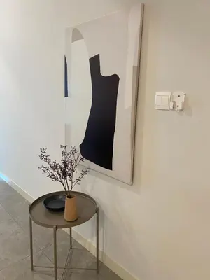 a table with a vase on it next to a wall at Ooak Residence in Mont Kiara, Kuala Lumpur in Kuala Lumpur