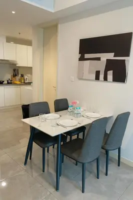 a dining room table with chairs and a kitchen at Ooak Residence in Mont Kiara, Kuala Lumpur in Kuala Lumpur