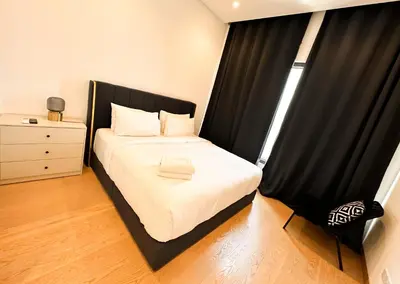 a bedroom with a bed with a black headboard and a window at Lucentia Residence by EAS Maju property in Kuala Lumpur