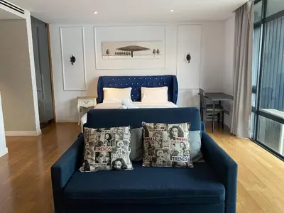 a blue couch in a room with a bed at Luxurious Condo in Heart of Kuala Lumpur with Rooftop Garden in Kuala Lumpur