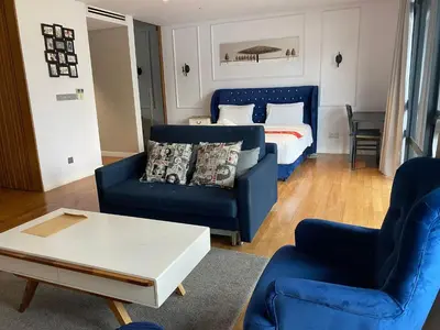 a living room with blue furniture and a bed at Luxurious Condo in Heart of Kuala Lumpur with Rooftop Garden in Kuala Lumpur