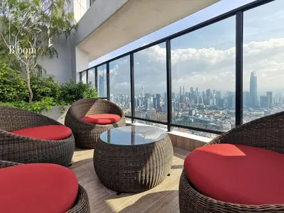 a balcony with chairs and tables and a view of the city at Trion KL High floor Corner Unit Free Parking Near TRX KL Centre and MRT in Kuala Lumpur