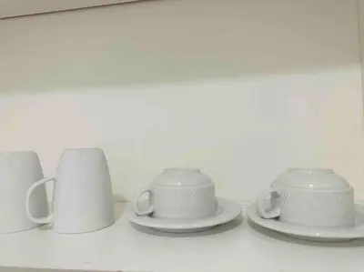 a group of white cups and saucers on a shelf at The Robertson Residence KL Bukit Bintang Chinatown Jalan Alor by \u54c1\u5c4b PINWU Shortstay in Kuala Lumpur