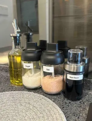 a counter with three bottles of oil and other ingredients at The Robertson Residence KL Bukit Bintang Chinatown Jalan Alor by \u54c1\u5c4b PINWU Shortstay in Kuala Lumpur