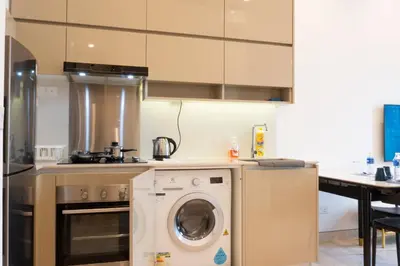 a kitchen with a washing machine and a stove at Lalaport Suites At Lucentia Bukit Bintang City Center in Kuala Lumpur