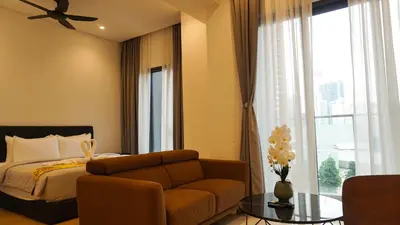 a bedroom with a bed and a couch and a window at Lalaport Suites At Lucentia Bukit Bintang City Center in Kuala Lumpur