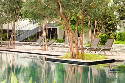 a group of chairs sitting next to a pool of water at LUCENTIA RESIDENCE BY HOME HORIZON in Kuala Lumpur