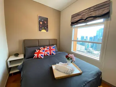 a bedroom with a bed with a tray on it at Sky Suite @ KLCC - 3BR KLCC View in Kuala Lumpur