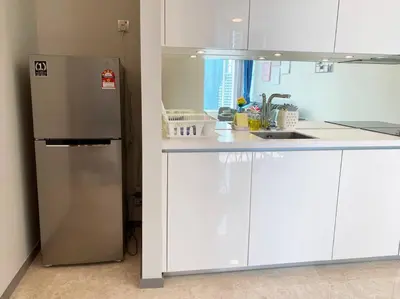 a kitchen with a stainless steel refrigerator and white cabinets at Sky Suite @ KLCC - 3BR KLCC View in Kuala Lumpur