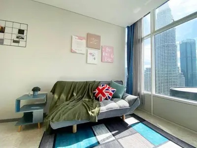 a living room with a couch and a large window at Sky Suite @ KLCC - 3BR KLCC View in Kuala Lumpur