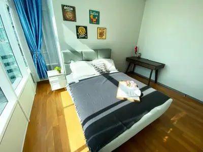 a bedroom with a large bed and a table at Sky Suite @ KLCC - 3BR KLCC View in Kuala Lumpur