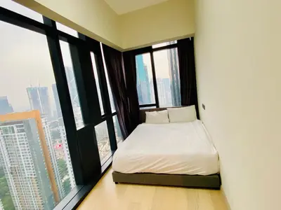 a bedroom with a bed in a room with windows at Star residence by KLCC in Kuala Lumpur
