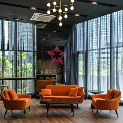 a lobby with two orange couches and a table at Star residence by KLCC in Kuala Lumpur