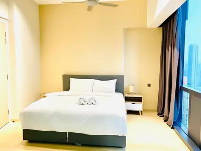 a bedroom with a large bed with white sheets at Star residence by KLCC in Kuala Lumpur