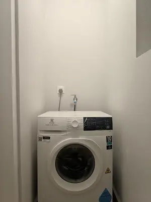 a washing machine in a corner of a room at Sentral Suites Kl Sentral By Luxe Home in Kuala Lumpur