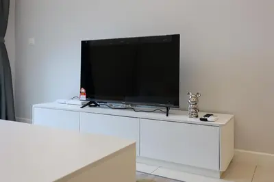 a flat screen tv sitting on top of a white entertainment center at Sentral Suites Kl Sentral By Luxe Home in Kuala Lumpur