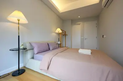 a bedroom with a large bed and a lamp at Sentral Suites Kl Sentral By Luxe Home in Kuala Lumpur