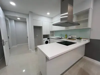 a kitchen with white cabinets and a white counter top at Sentral Suites Kl Sentral By Luxe Home in Kuala Lumpur