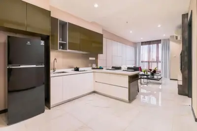 a kitchen with white cabinets and a black refrigerator at 8 Kia Peng Suites KLCC by Luna in Kuala Lumpur
