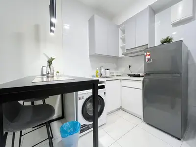 a white kitchen with a sink and a dishwasher at Arte Mont Kiara by Yan Yee in Kuala Lumpur