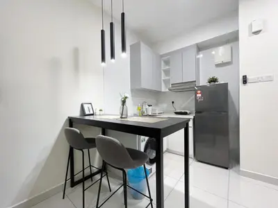 a kitchen with a black table and two stools at Arte Mont Kiara by Yan Yee in Kuala Lumpur