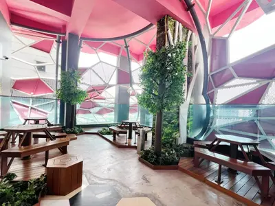 a room with tables and trees and pink ceilings at Arte Plus Ampang in Kuala Lumpur