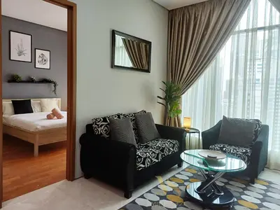 a living room with a couch and a table and a bed at Soho Suites KLCC by Minsha in Kuala Lumpur