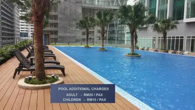 a large swimming pool with palm trees in a building at Soho Suites KLCC by Minsha in Kuala Lumpur