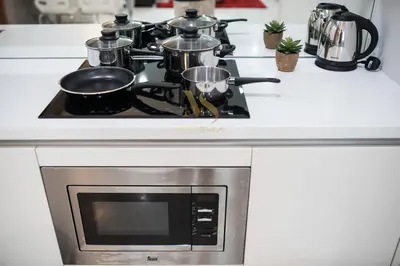 a stove with pots and pans on top of it at Soho Suites KLCC by Minsha in Kuala Lumpur