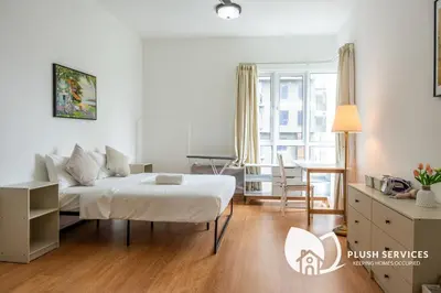 a white bedroom with a bed and a table at Inspirasi@Mont Kiara in Kuala Lumpur