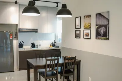 a kitchen with a table and chairs and a refrigerator at Inspirasi@Mont Kiara in Kuala Lumpur