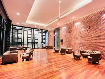 a large room with chairs and a brick wall at Chambers Platinum Suite Kuala Lumpur in Kuala Lumpur