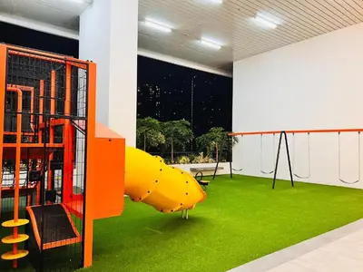 a playground with a yellow slide on green grass at Chambers Platinum Suite Kuala Lumpur in Kuala Lumpur