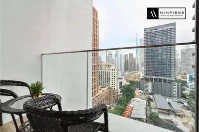 a balcony with a table and chairs and a view of a city at Quill Residences Suite by Mimpi B&B in Kuala Lumpur