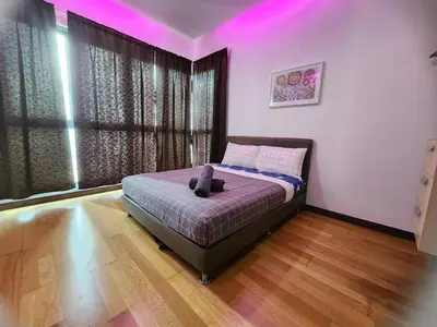 a bedroom with a bed with purple lights on it at Regalia Suites Kuala Lumpur KLCC in Kuala Lumpur