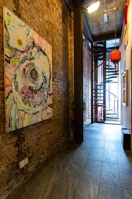 a painting hanging on a brick wall in a hallway at Travel Hub Highstreet in Kuala Lumpur