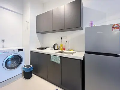 a kitchen with a refrigerator and a washing machine at Colony By Infinitum in Kuala Lumpur